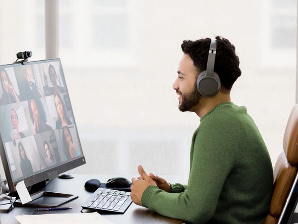 Man with headphones video conferencing on a computer.