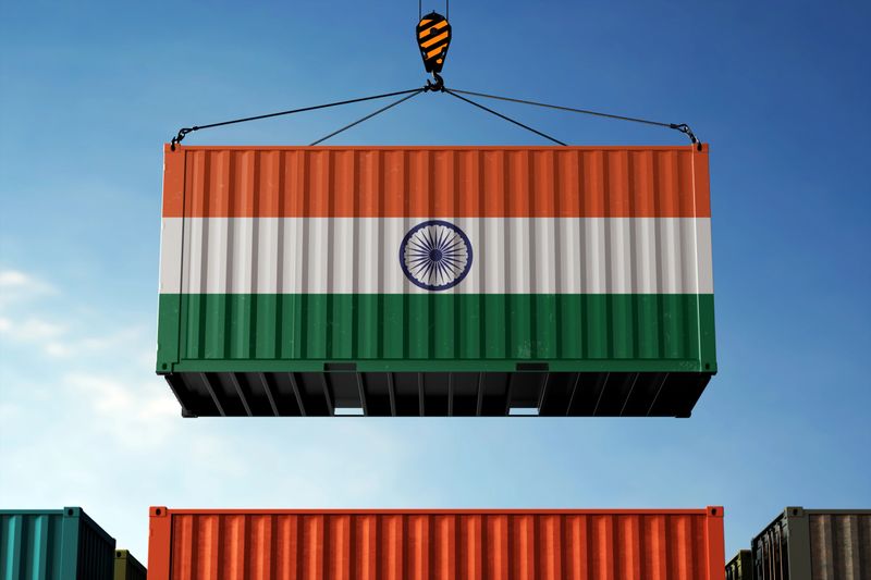 India trade cargo container hanging against clouds background