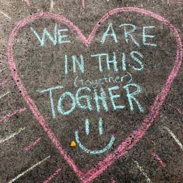 Chalk heart with supportive message on pavement.
