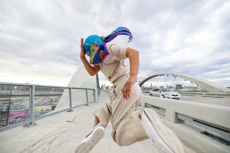 Young woman breakdancing in the city streets.