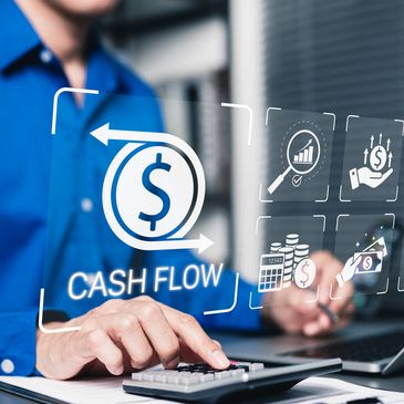 Person calculating cash flow using a calculator and laptop with financial icons.
