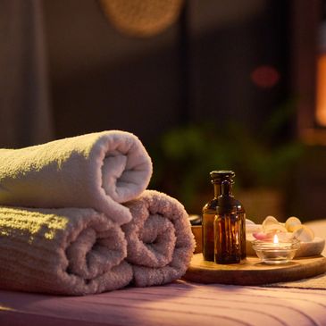massage table with towels, candles, and oils