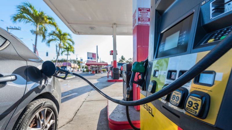 Car refueling at a gas station on a sunny morning.