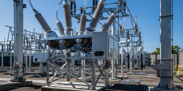 Electrical substation equipment under clear sky.