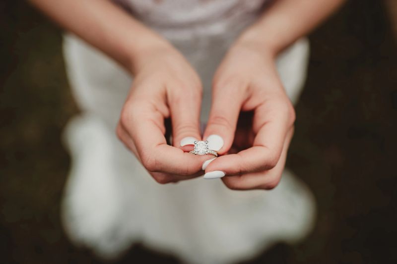 Close up of bride holding diamond wedding ring