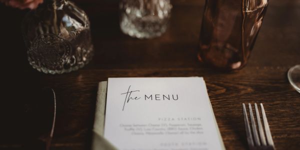 Elegant menu on a wooden table with cutlery.