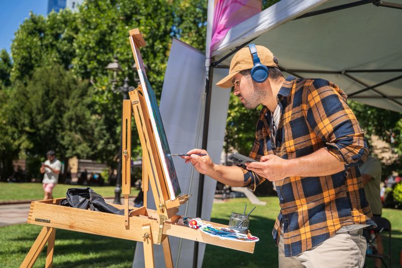 An enthusiastic artist creates a stunning outdoor masterpiece, showcasing vibrant colors and immense creativity