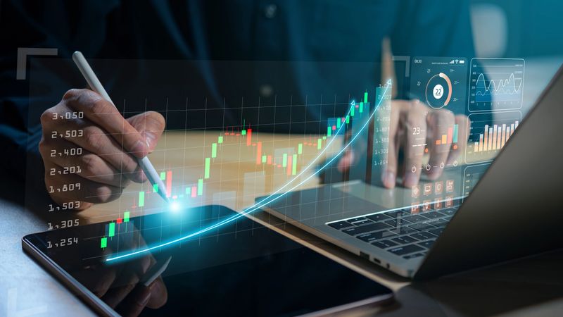 An analyst leverages a computer and dashboard to conduct data-driven business analysis, employing a Data Management System with connected KPIs and metrics from the database, to optimize technology, finance, operations, sales, and marketing strategies.