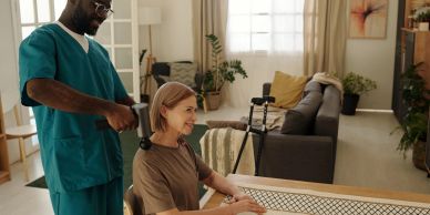 Healthcare professional uses massage gun on woman's neck in cozy room.