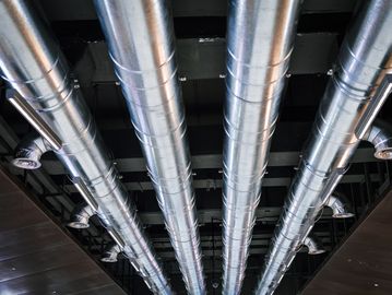 Metal air ducts on a ceiling in a building.