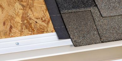 Close-up of roof shingles being installed on a wooden roof base.