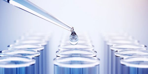 Scientist in protective gear working in a high-tech laboratory with advanced equipment.