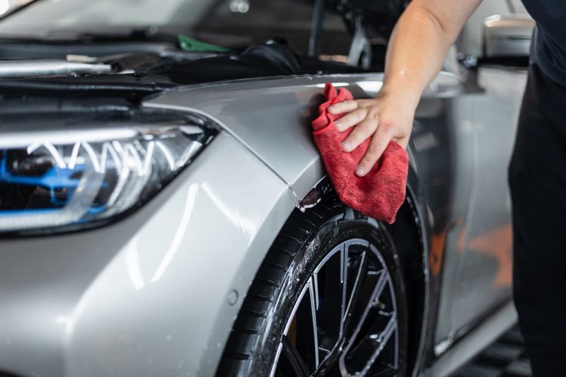 professional man wipes and dries a car with a rag. Car wrapping with protective film