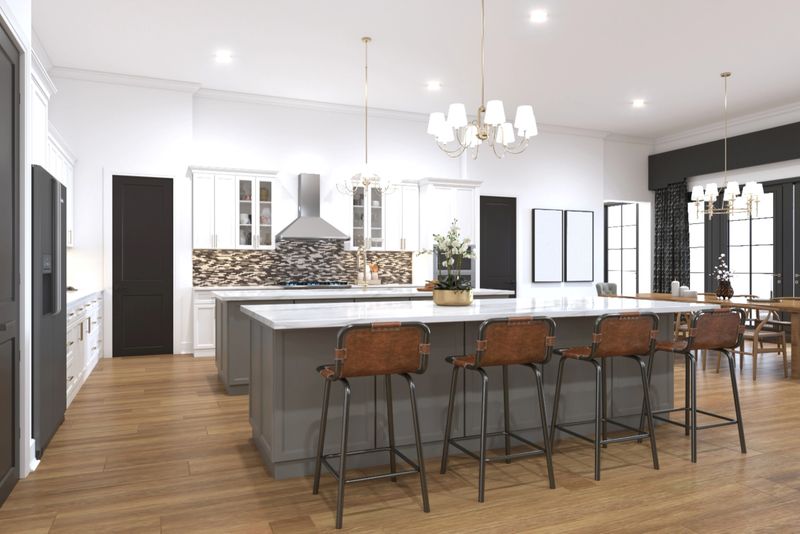 Bright and elegant kitchen featuring a contemporary design with a large island, leather seats, decorative chandeliers, and white cabinetry, creating a welcoming and functional culinary space.