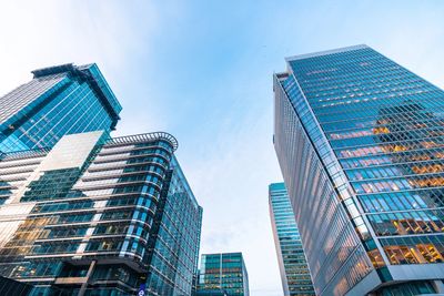 Modern glass skyscrapers under a clear blue sky in an urban setting.