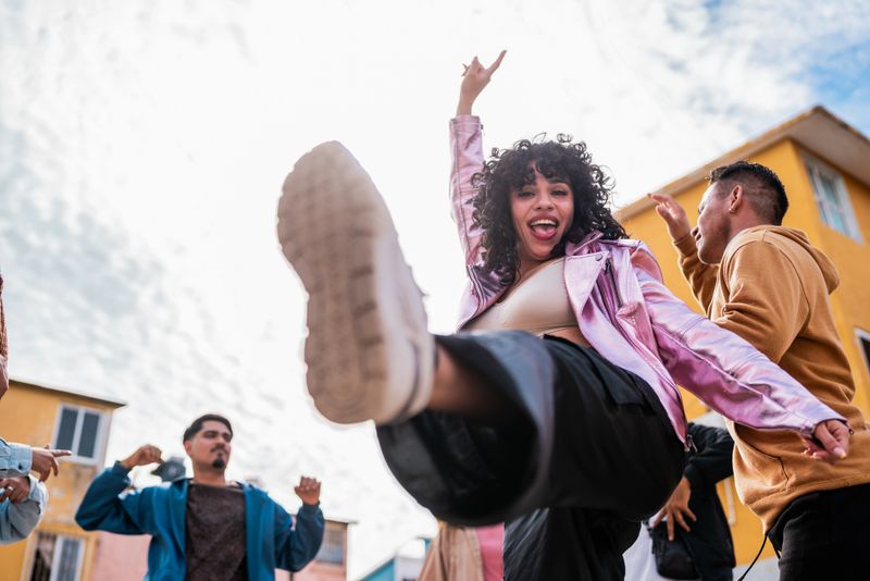 Young woman dancing with friends outdoors