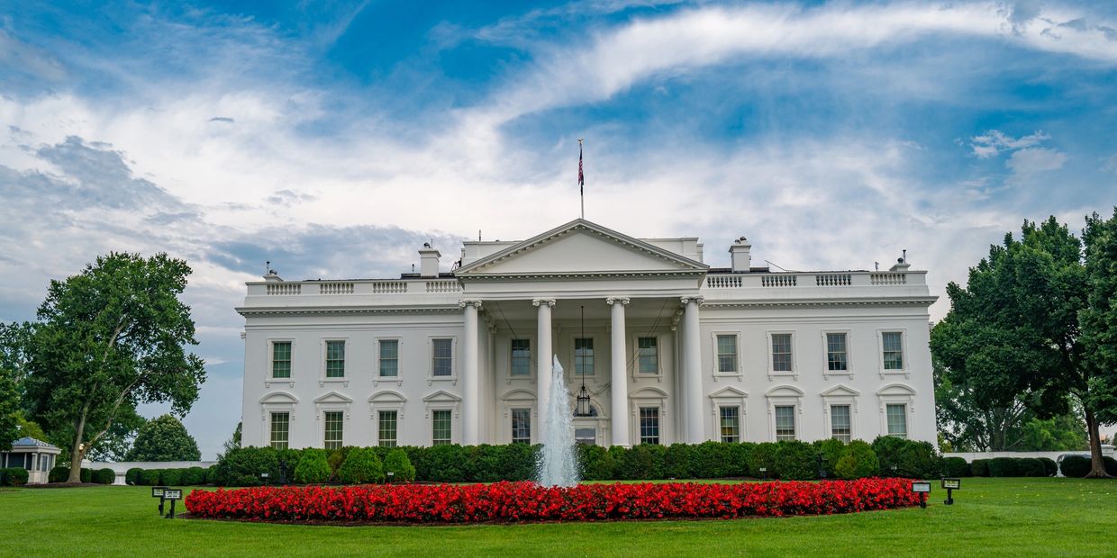 The White House with a blue sky and red flowers.