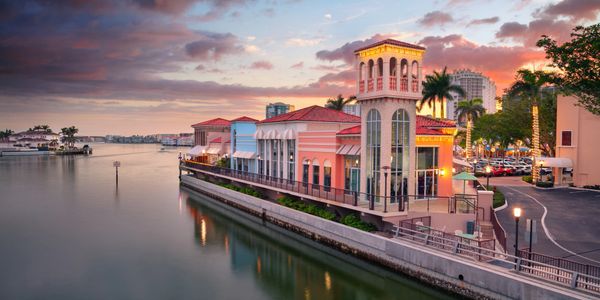 A colorful building by a calm waterfront at sunset.