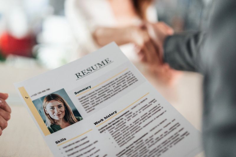 A candidate confidently presents their resume during a job interview with a panel of professionals. The image highlights the significance of effective communication and first impressions in the pursuit of career opportunities and growth.