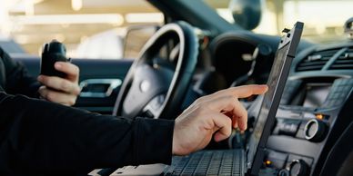 A man inside the car and Looking on the laptop screen