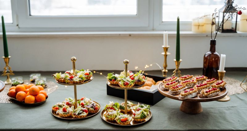 A beautifully set dining table with plates of delicious food and elegantly lit candles creates a warm atmosphere, ideal for sharing meals and deepening connections with loved ones