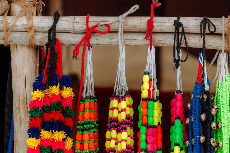 A vibrant collection of colorful handmade items displayed on a wooden rack. These items showcase traditional Indian craftsmanship and vibrant festival decor, enhancing their cultural and aesthetic appeal.