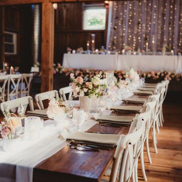 Elegant wedding reception table with floral arrangements and soft lighting.