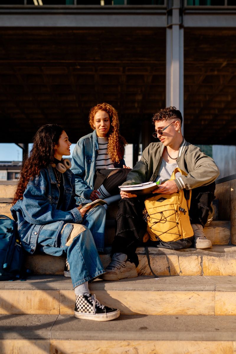 Group of diverse college students reviewing notes and preparing for exams on campus steps