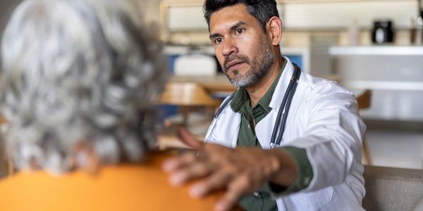 Doctor comforting an elderly patient during a consultation.