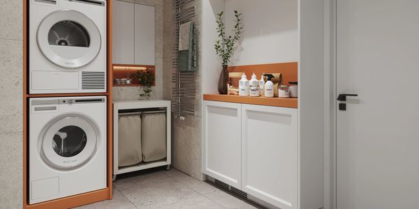 A woman folding clothes in a modern laundry room.