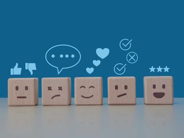 Wooden blocks with emoticons representing different emotions and feedback icons.