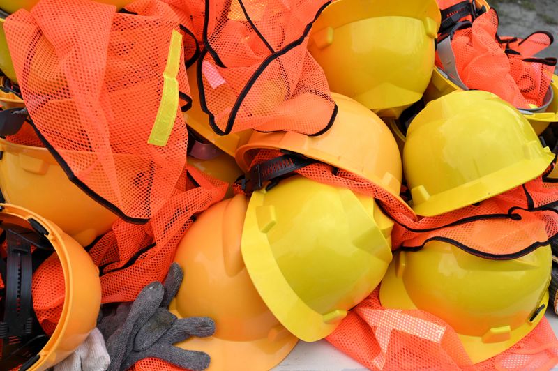Pile of project worker helmets on table