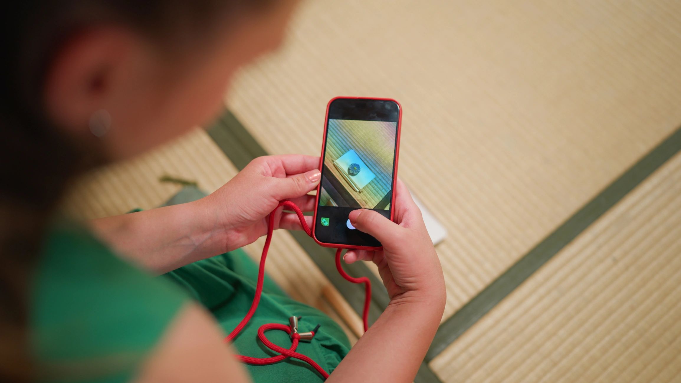 Person taking a photo of a small item with a smartphone.