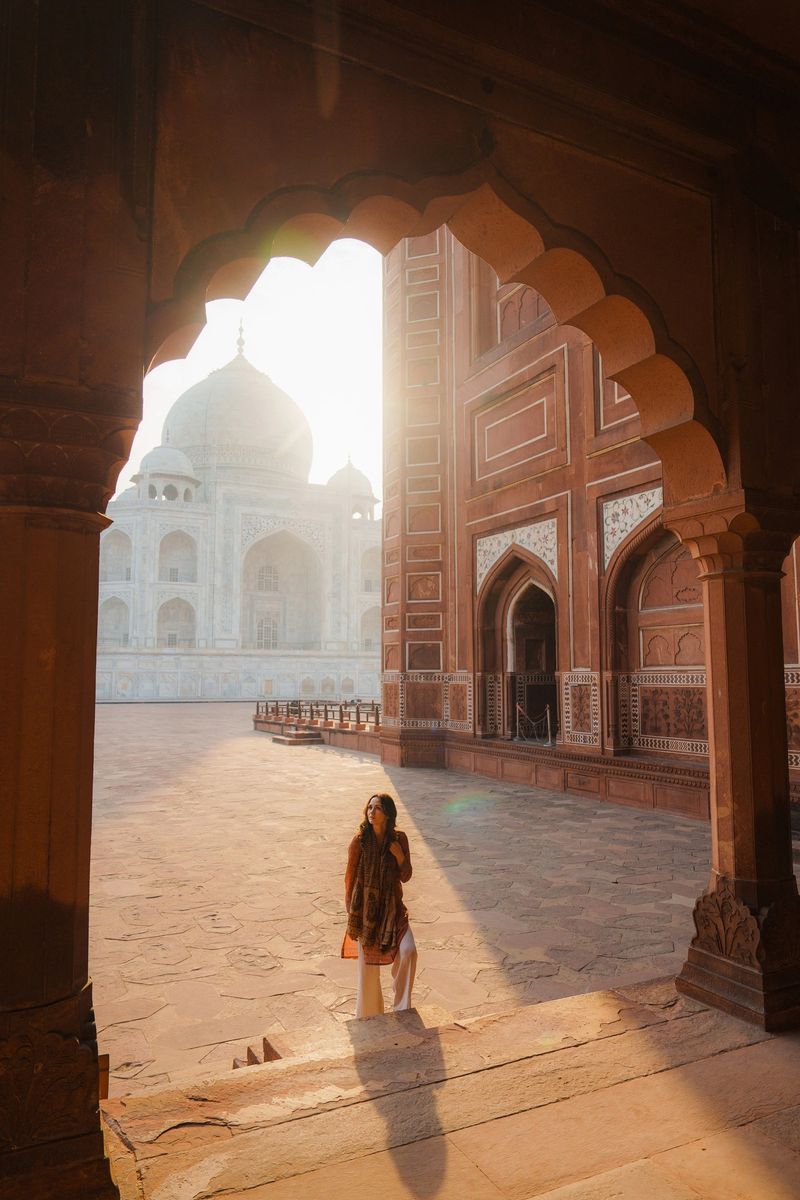 Woman exploring awe-inspiring Taj Mahal at sunrise during trip to India
