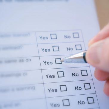 Person marking 'Yes' on a questionnaire form with a pen.