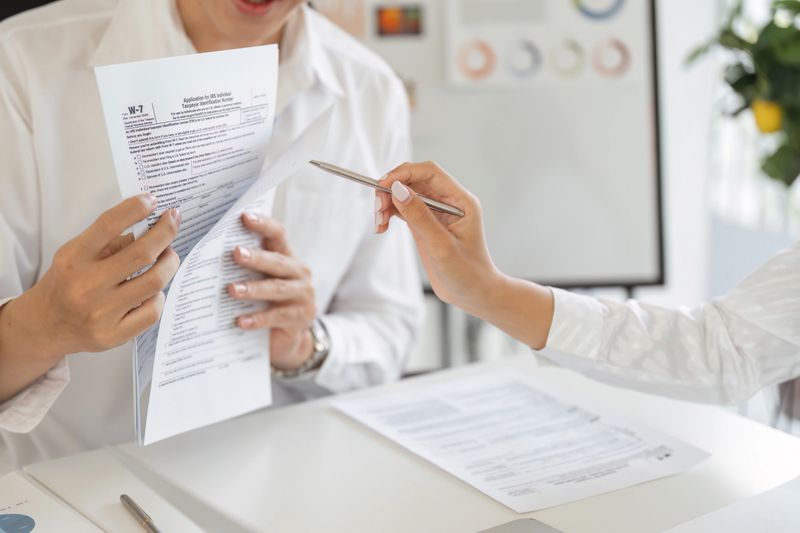 A tax professional assists a client in reviewing their W-2 form, focusing on accurate tax filing and financial guidance.