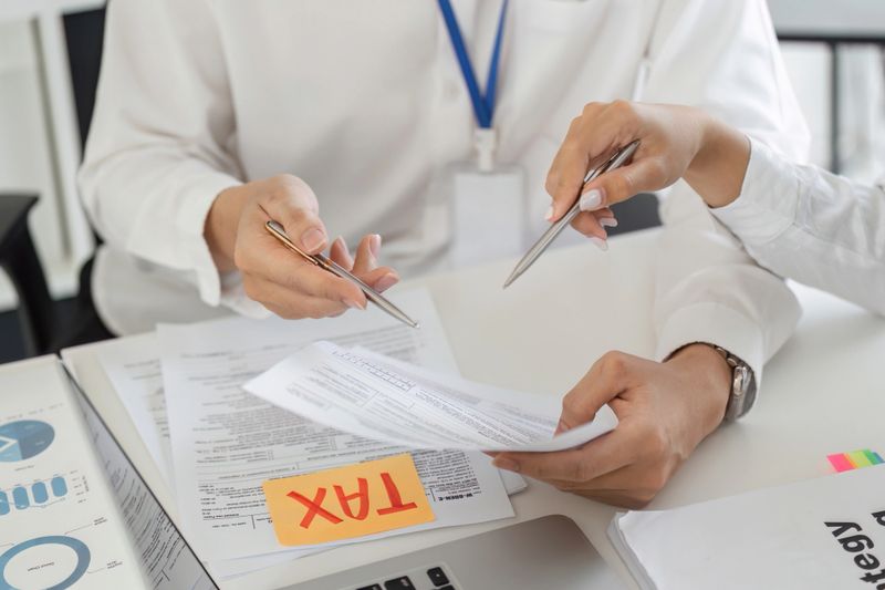 Two professionals engage in a discussion over tax forms, strategizing financial plans in a collaborative environment.