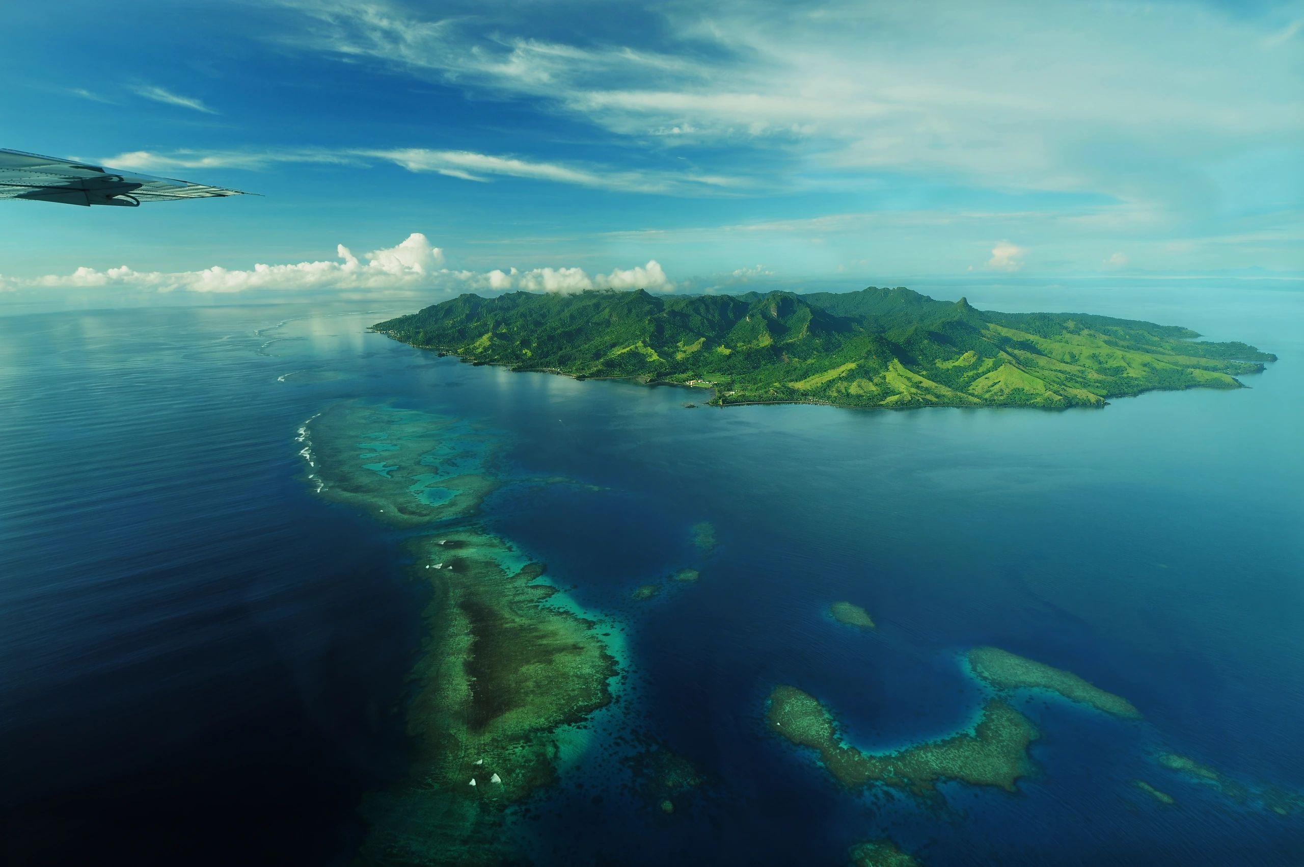 Aerial view of a green island surrounded by blue ocean.