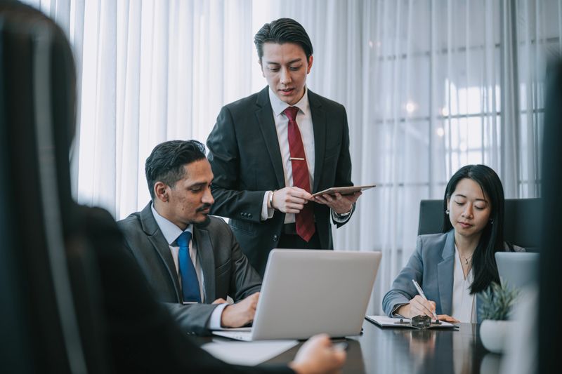 Asian Entrepreneur Business merger and Acquisitions signing documents agreement in meeting room