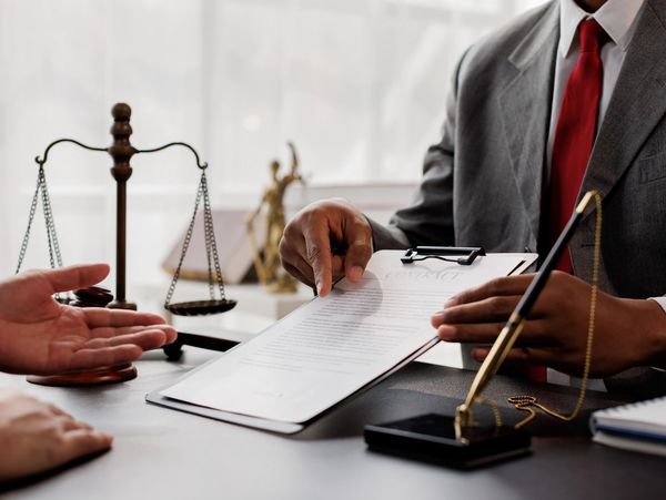 Lawyer explaining contract terms to client at office desk.