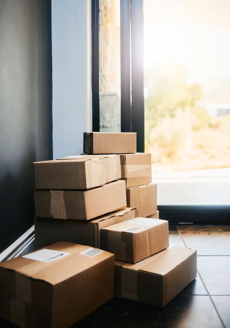 A neatly stacked arrangement of brown cardboard boxes near a doorway, showcasing a recent delivery.