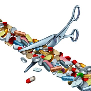 Scissors cutting through a stream of colorful pills and capsules.