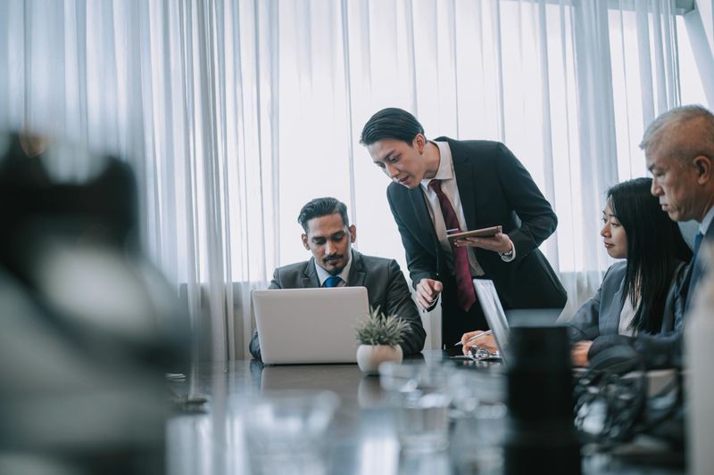 Asian Chinese young lawyer explaining showing agreement legal document in business meeting discussion in meeting room