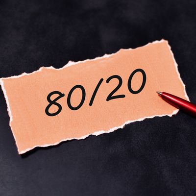 A torn paper with 80/20 written and a red pen beside it.