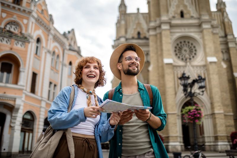 Young couple using a map to explore the new city on their vacation.