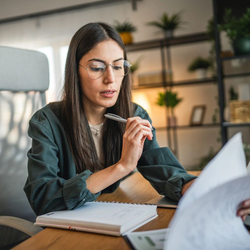 Adult woman work on laptop and use notebook from home office