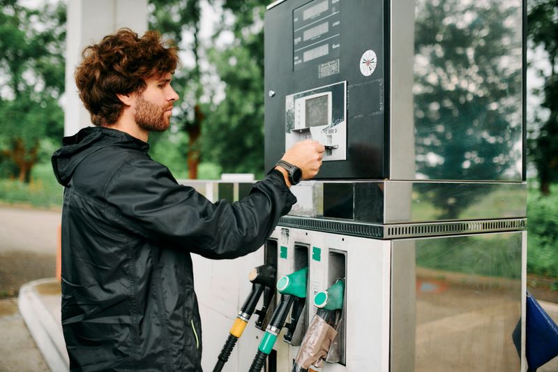 Machine, man or gas station with card, fuel and transport cost for energy, drive or quality petrol service. Payment, gasoline or vehicle maintenance at garage to refuel tank with diesel on road trip