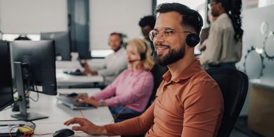 A Helpdesk technician wearing a headset and smiling