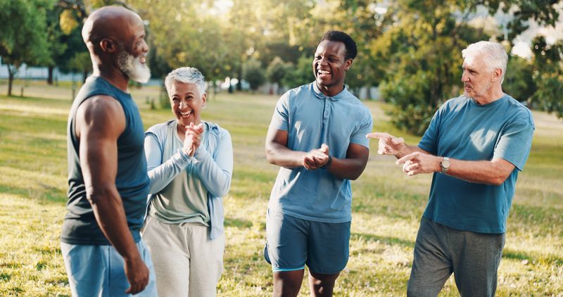 Happy people, fitness and applause with personal trainer for workout achievement, goals or congratulations in nature. Man, coach or instructor clapping with mature group for exercise at outdoor park