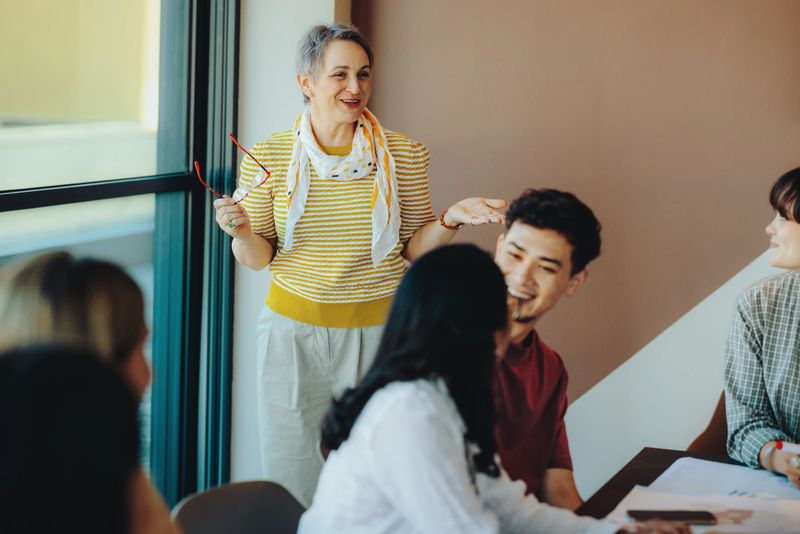 A joyful high school teacher interacts with students during an engaging classroom session, fostering a positive learning environment.